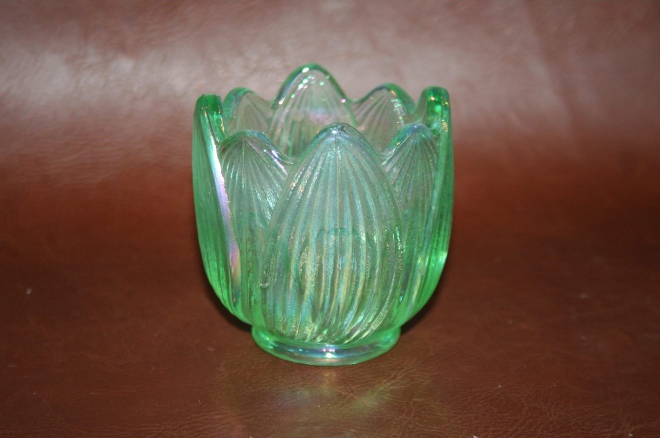 A tulip-shaped uranium-glass votive holder with petalled sides, pale green